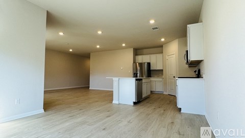 A kitchen with white cabinets and a wooden floor.