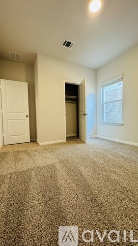 A room with a carpeted floor and a window.