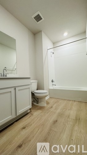 A bathroom with a toilet, sink, and bathtub.