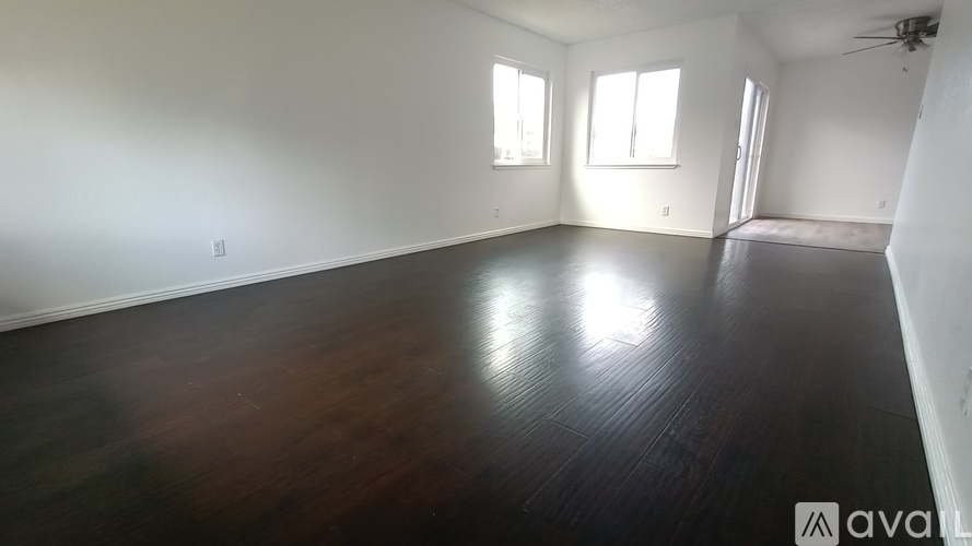 A room with wooden floors and two windows.