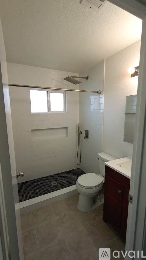 A bathroom with a toilet, sink, and shower.