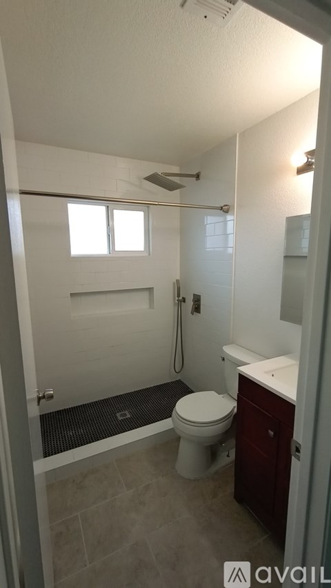 A bathroom with a toilet, sink, and shower.