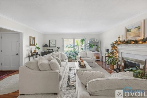 A living room with a white couch and a fireplace.