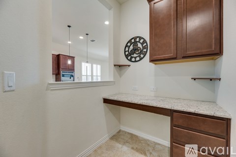 A kitchen with brown cabinets and a marble countertop.