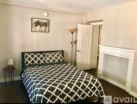 A bedroom with a large bed and a fireplace.