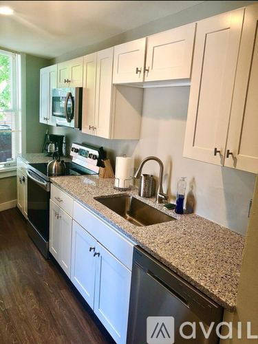 A kitchen with granite countertops and white cabinets.