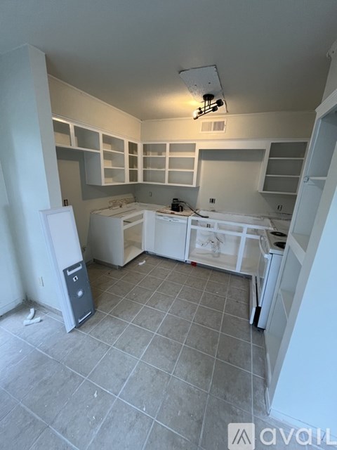 A kitchen with white appliances and cabinets is available for rent.