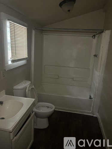 A bathroom with a toilet, sink, and bathtub.