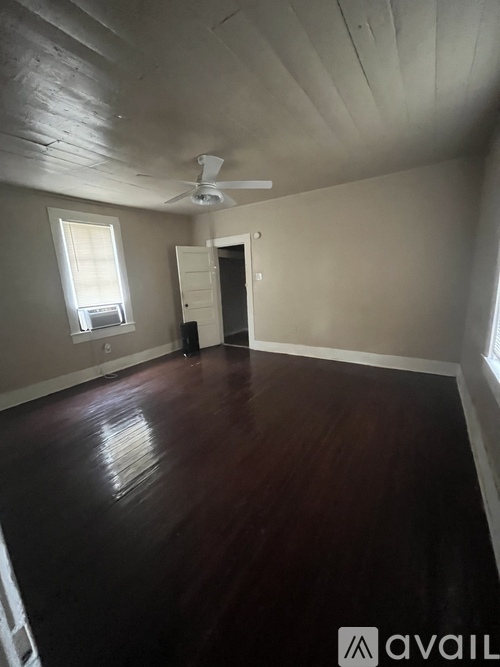 A room with wooden floors and a ceiling fan.
