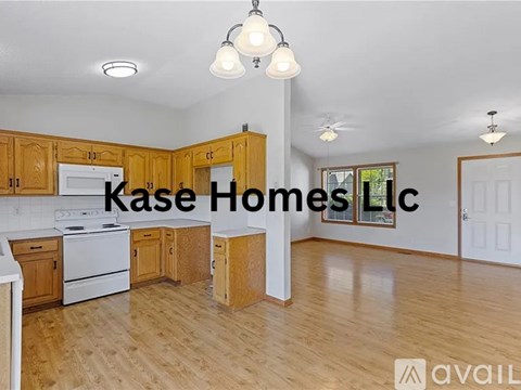 A kitchen with wooden cabinets and a white stove is available for rent.