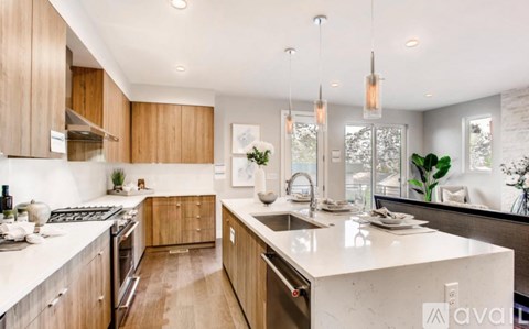 A modern kitchen with wooden cabinets and a white countertop.