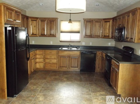 A kitchen with wooden cabinets and black appliances.