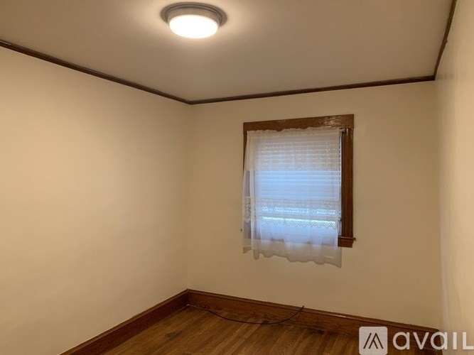 A room with a window and wooden flooring.