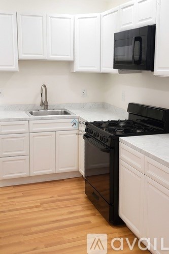 A kitchen with white cabinets and a black stove top oven.