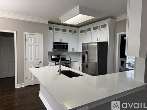 A kitchen with white cabinets and a white island.