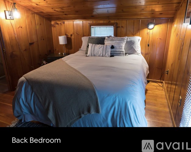 A bedroom with a bed and wooden walls.