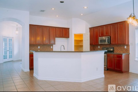 A kitchen with brown cabinets and a white island.