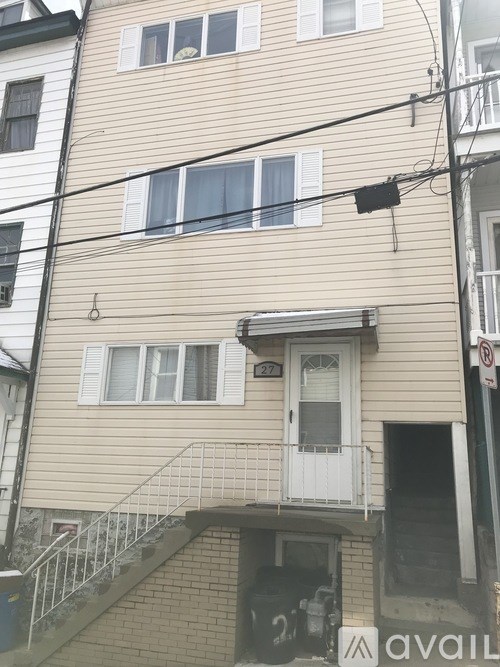 A beige building with a black awning and a white door.