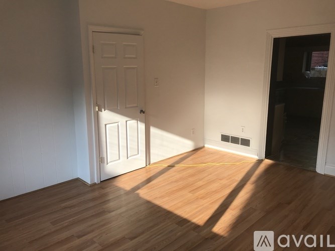 A room with wooden floors and a white door.