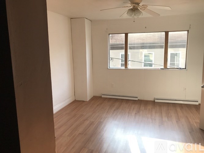 A room with a ceiling fan and a window.