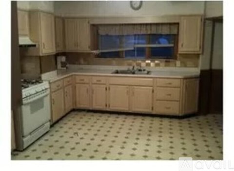 A kitchen with wooden cabinets and a white dishwasher.