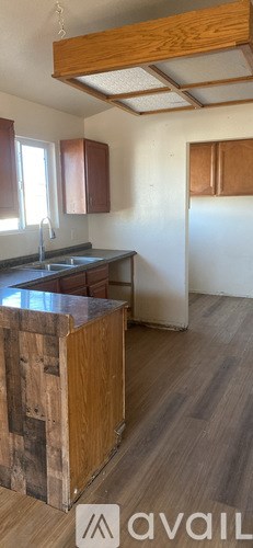 A kitchen with wooden cabinets and a wooden island.