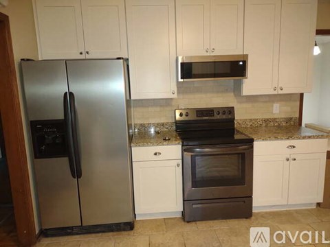 A kitchen with a stainless steel refrigerator and a black oven.