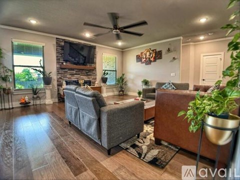 A living room with a grey couch and a wooden floor.