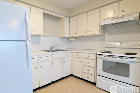 A kitchen with white appliances and cabinets.