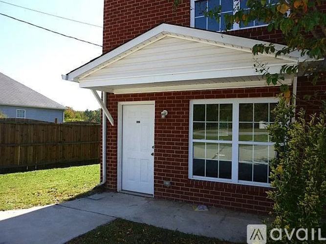 A red brick house with a white door and windows.