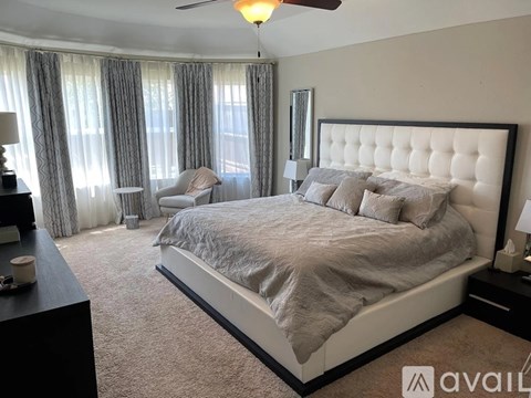A bedroom with a large bed and a ceiling fan.