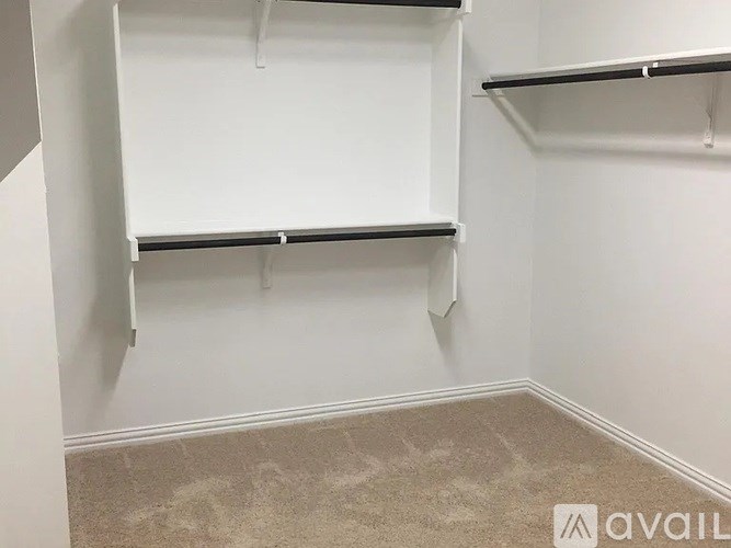 Empty white shelves in a room with beige carpet.