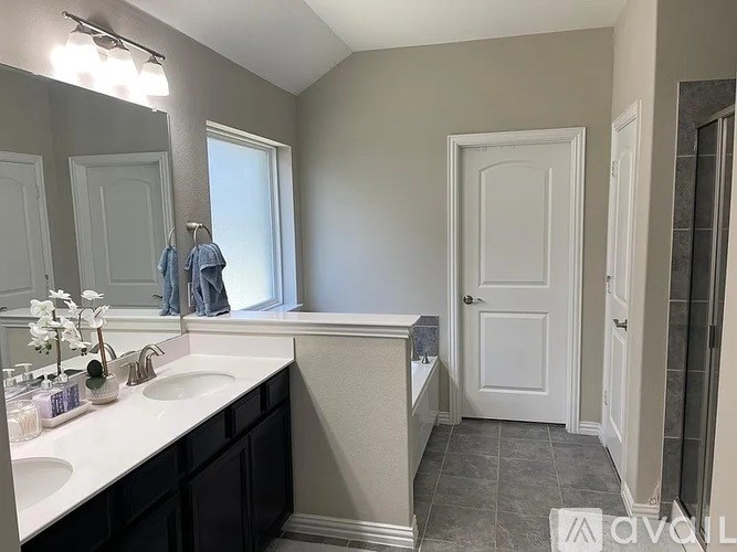 A bathroom with a white sink and a white door.