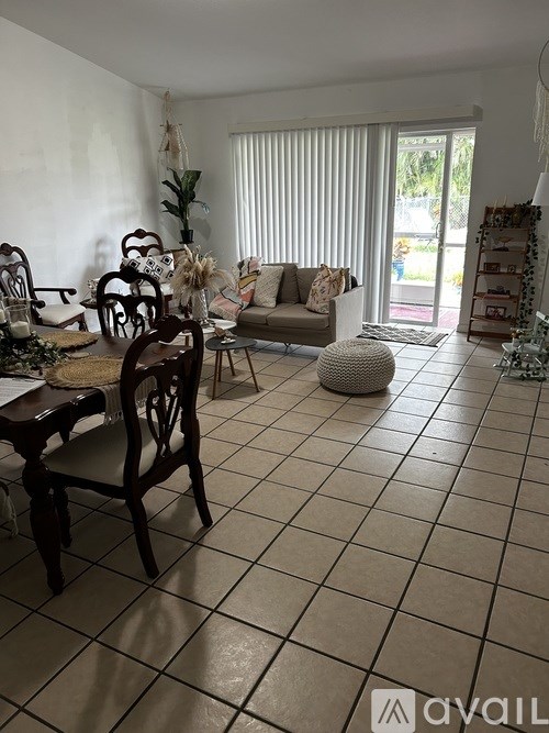 A living room with a couch, chairs, and a table.