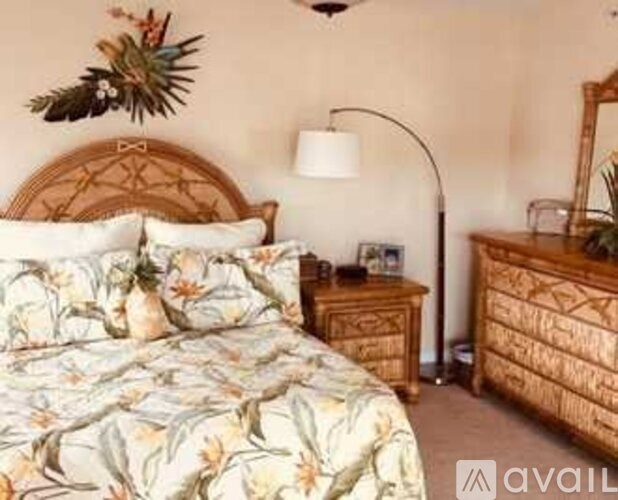 A bedroom with a bed, nightstand, and lamp.