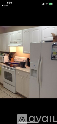 A kitchen with white cabinets and appliances.