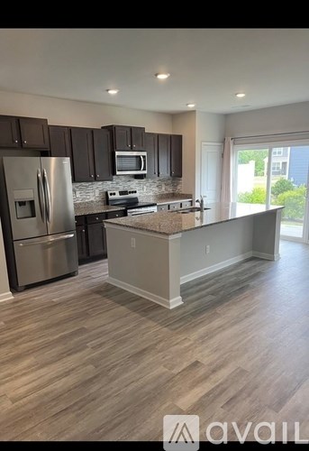 A kitchen with a refrigerator, microwave, and oven.