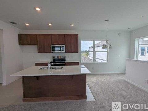 A kitchen with brown cabinets and a white countertop is available for rent.