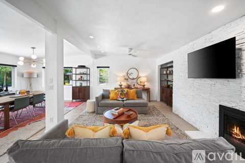 A living room with a grey couch and a fireplace.