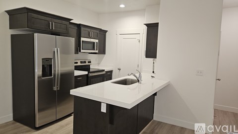 A kitchen with black cabinets and stainless steel appliances.