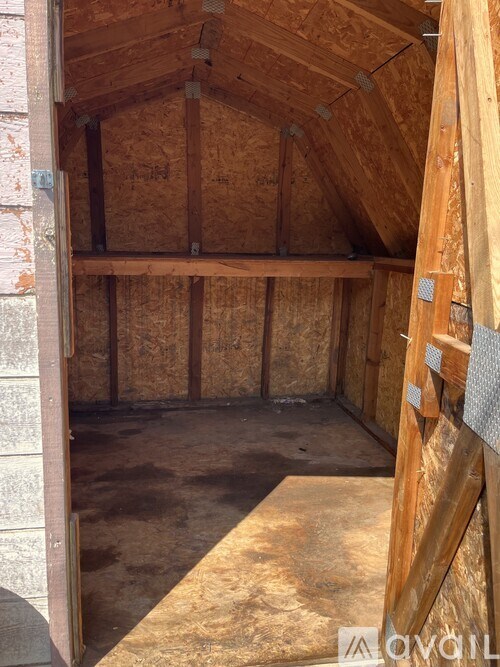 A room under construction with wooden beams and insulation.