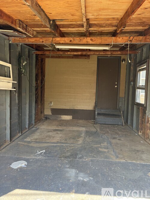 A room under construction with a wooden ceiling and exposed beams.