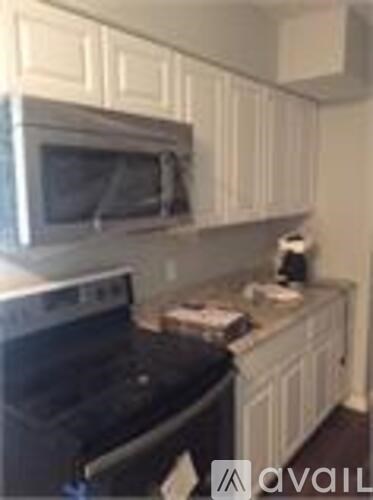 A kitchen with white cabinets and a black oven.