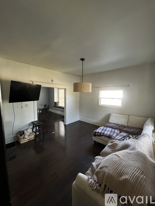 A living room with a couch, a chair, and a television.