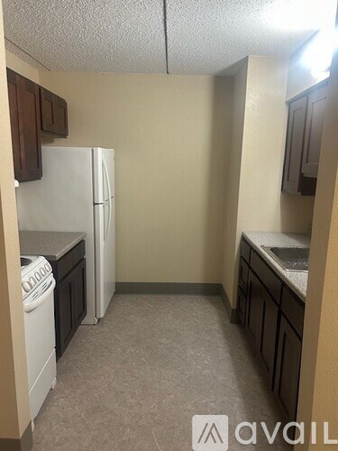 A small kitchen with a white refrigerator and a washing machine.