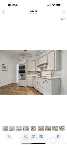 A kitchen with white cabinets and a fridge.