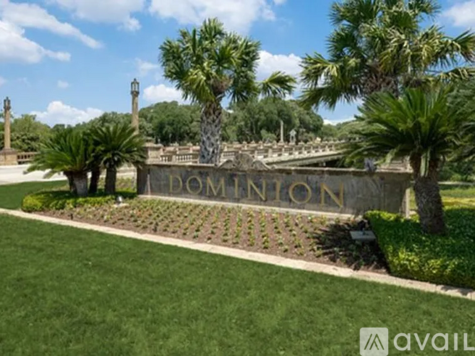 A sign that says Dom Inton is in front of a row of palm trees.
