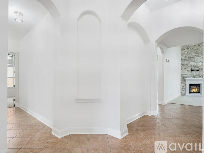 A spacious room with arched doorways and a fireplace.