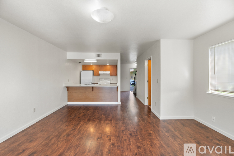 A spacious room with wooden floors and white walls.