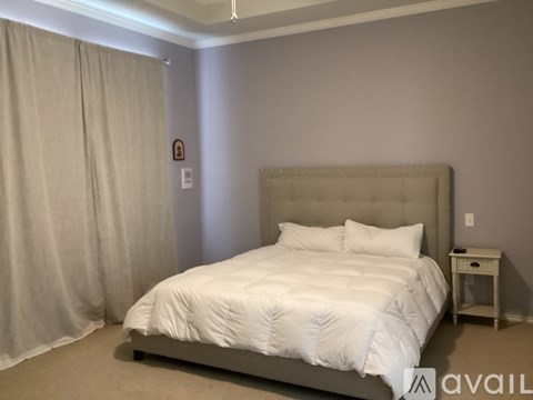 A bedroom with a large bed and a small table.